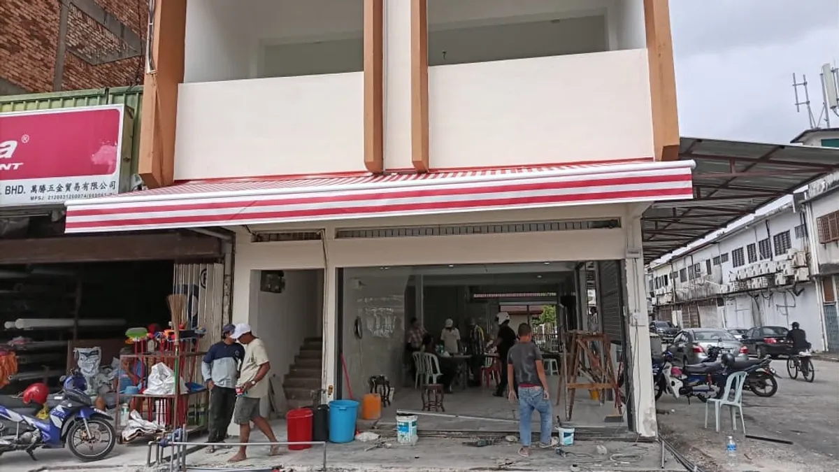 A red and white striped awning across a new shop lot, with the shutter open below it